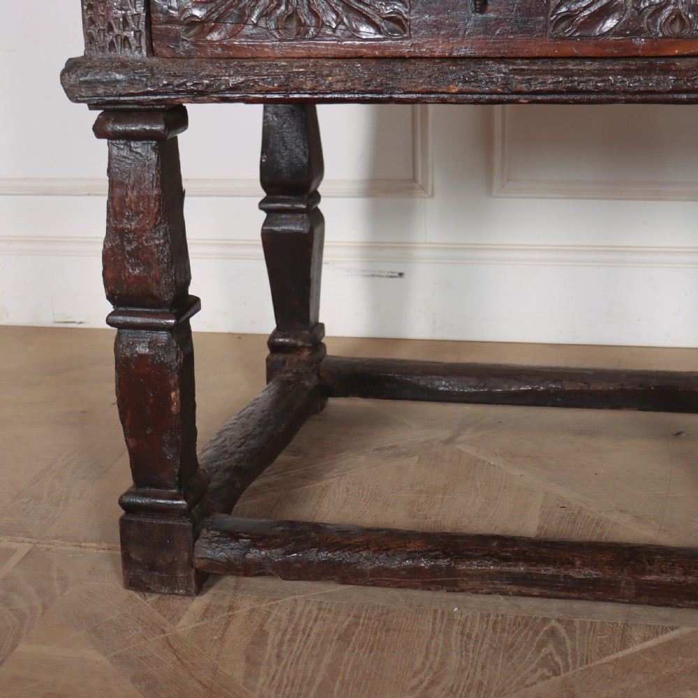A 17th-century Spanish dark oak console table featuring carved drawer fronts with rosette motifs, turned legs, iron handles, and a box stretcher base. View II