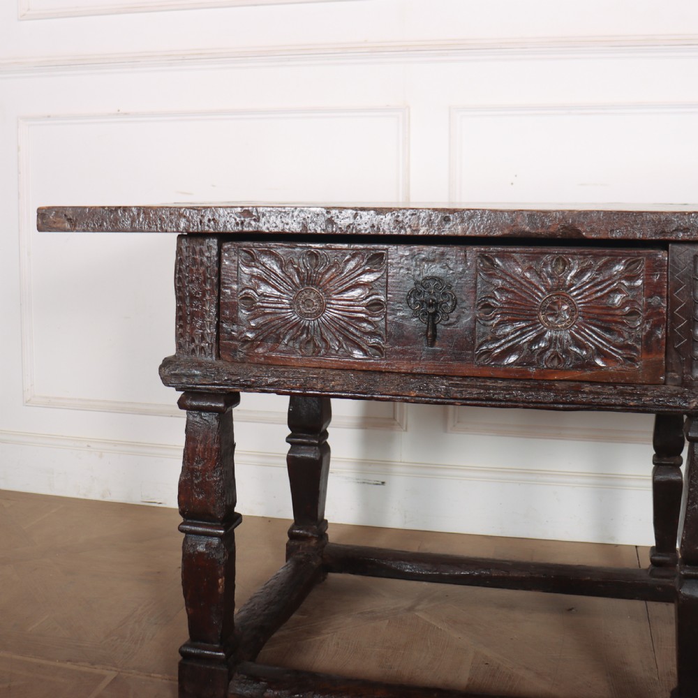 A 17th-century Spanish dark oak console table featuring carved drawer fronts with rosette motifs, turned legs, iron handles, and a box stretcher base. View III
