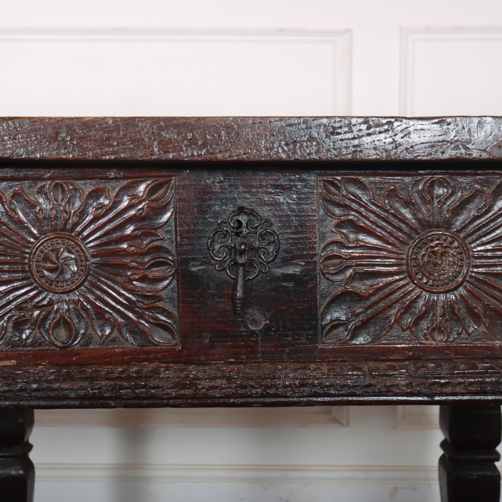 A 17th-century Spanish dark oak console table featuring carved drawer fronts with rosette motifs, turned legs, iron handles, and a box stretcher base. View VIII