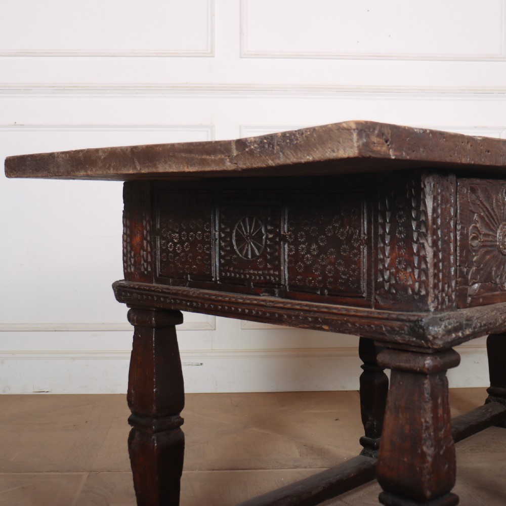 A 17th-century Spanish dark oak console table featuring carved drawer fronts with rosette motifs, turned legs, iron handles, and a box stretcher base. View XII