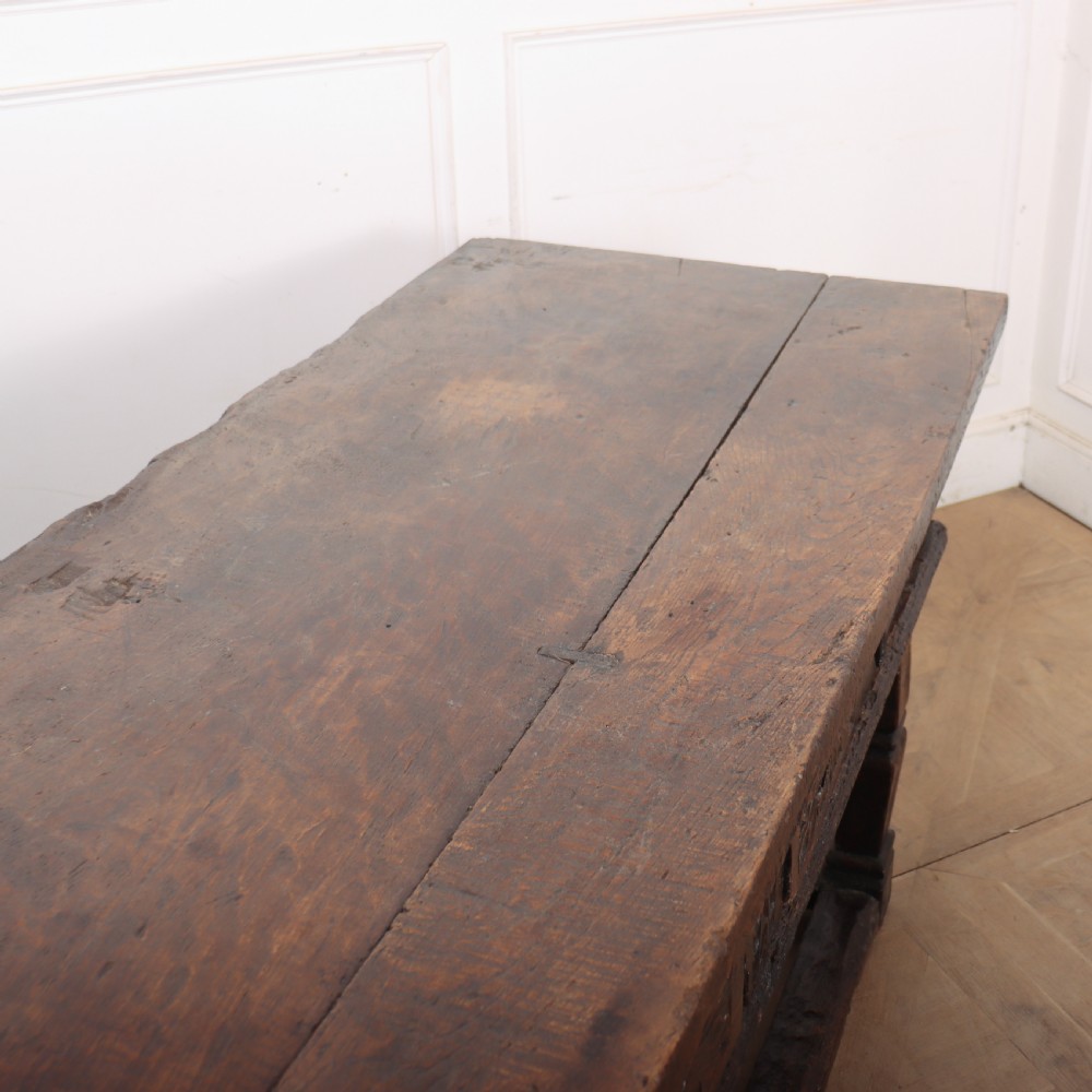A 17th-century Spanish dark oak console table featuring carved drawer fronts with rosette motifs, turned legs, iron handles, and a box stretcher base. View XIV