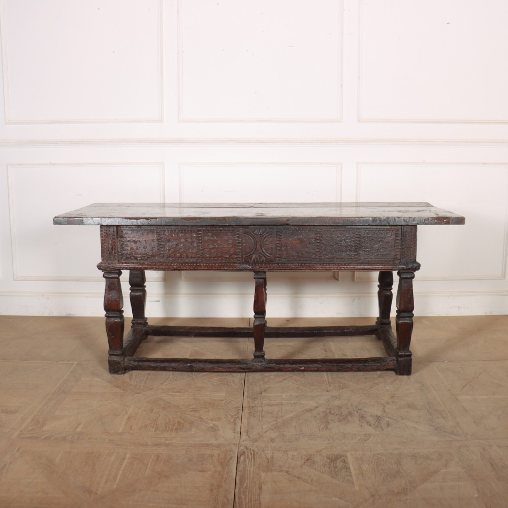 A 17th-century Spanish dark oak console table featuring carved drawer fronts with rosette motifs, turned legs, iron handles, and a box stretcher base. View XV