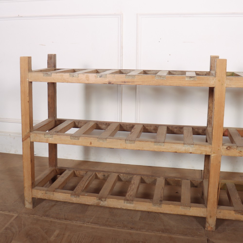 A three-tier slatted pine shoe rack with vertical support posts and a natural unvarnished wood finish. View II