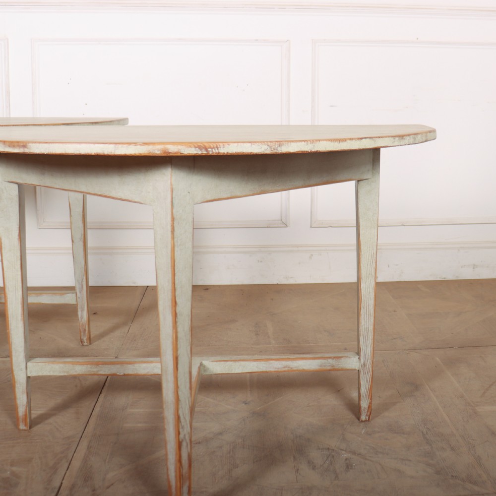 A pair of antique Swedish semi-circular console tables featuring a distressed pale grey painted finish, simple aprons, and straight tapered legs with stretchers. View IV