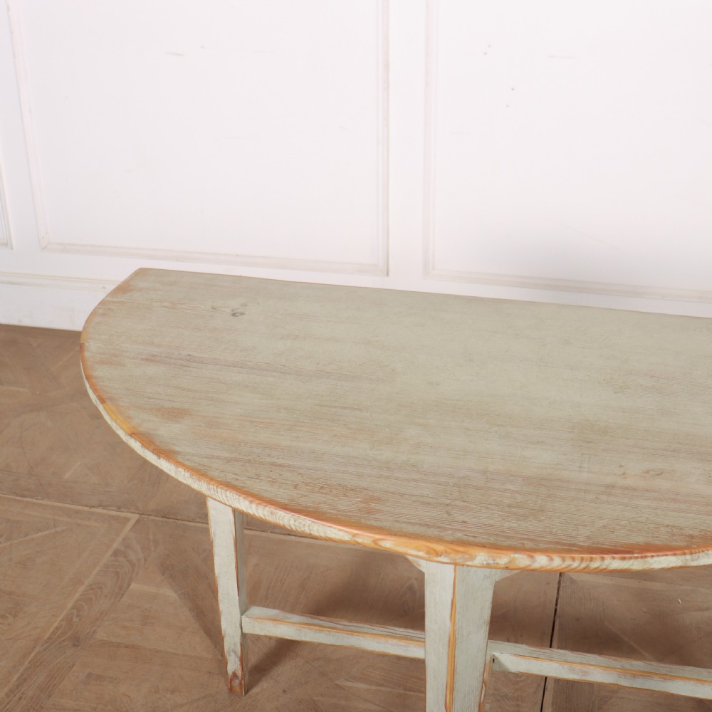 A pair of antique Swedish semi-circular console tables featuring a distressed pale grey painted finish, simple aprons, and straight tapered legs with stretchers. View VIII