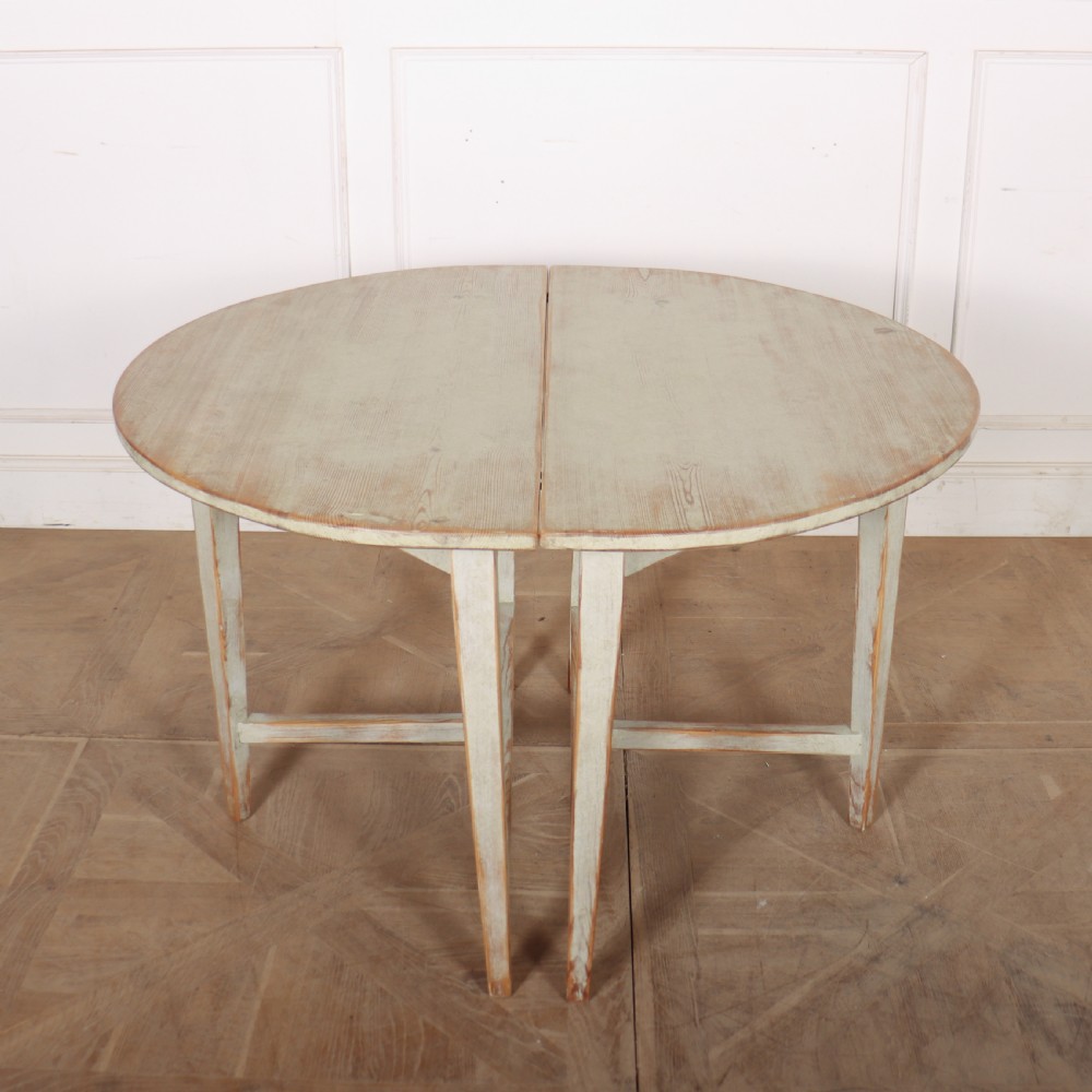 A pair of antique Swedish semi-circular console tables featuring a distressed pale grey painted finish, simple aprons, and straight tapered legs with stretchers. View X