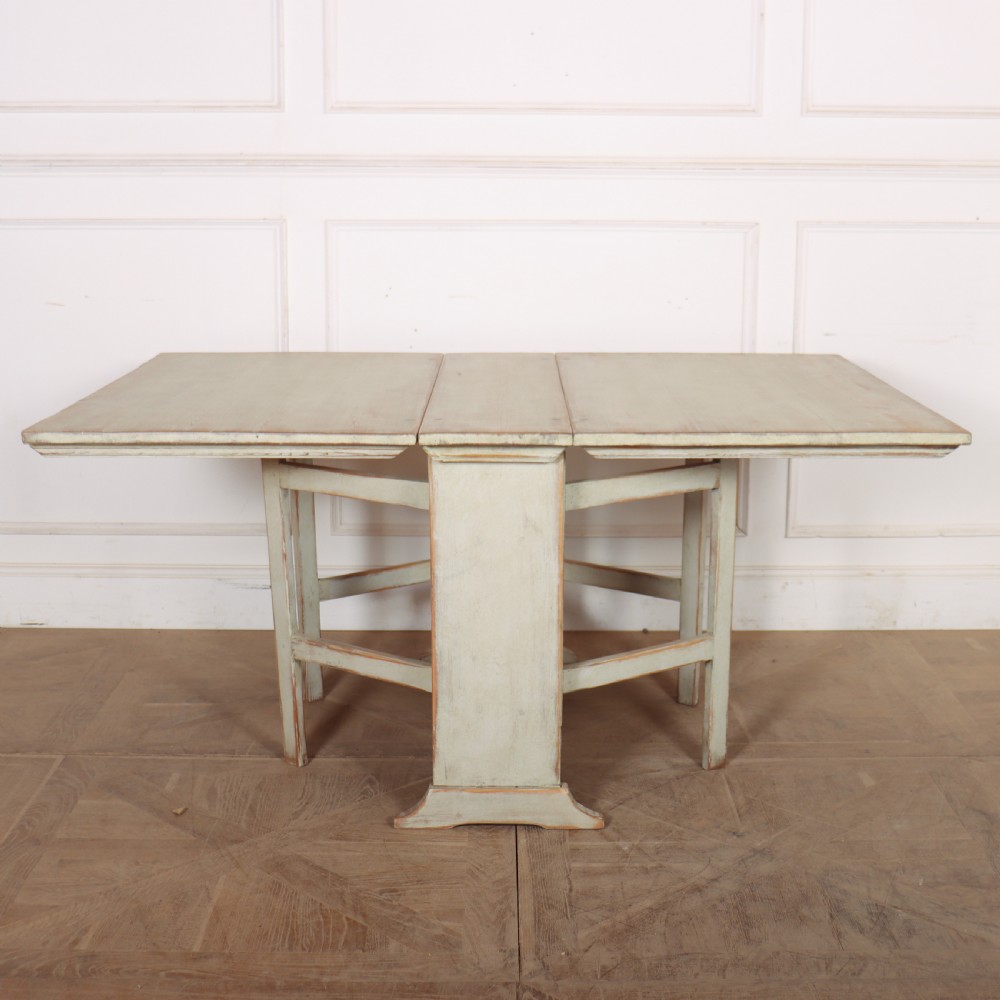 A folded Swedish slagbord drop-leaf dining table with distressed pale green paint over pine timber. View V