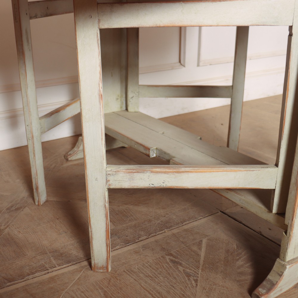 A folded Swedish slagbord drop-leaf dining table with distressed pale green paint over pine timber. View IX