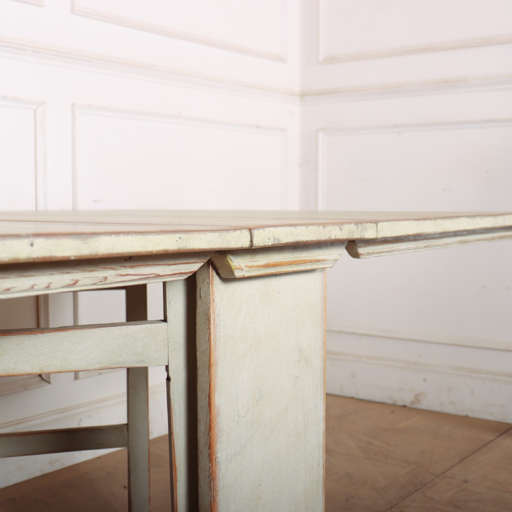 A folded Swedish slagbord drop-leaf dining table with distressed pale green paint over pine timber. View X