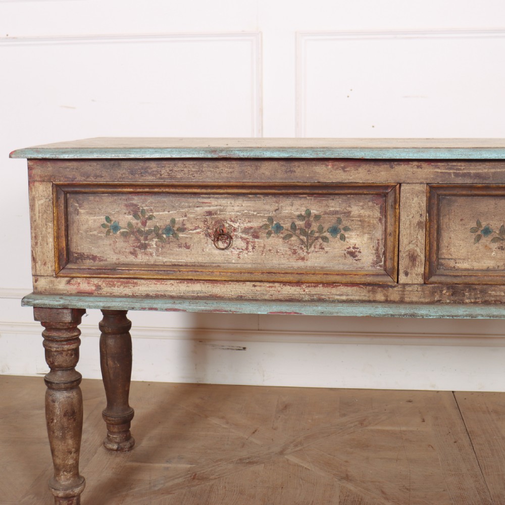 A long colonial painted wooden serving table featuring two drawers decorated with hand-painted floral motifs, brass ring handles, and four turned legs. View II