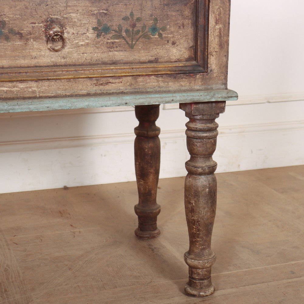 A long colonial painted wooden serving table featuring two drawers decorated with hand-painted floral motifs, brass ring handles, and four turned legs. View IV