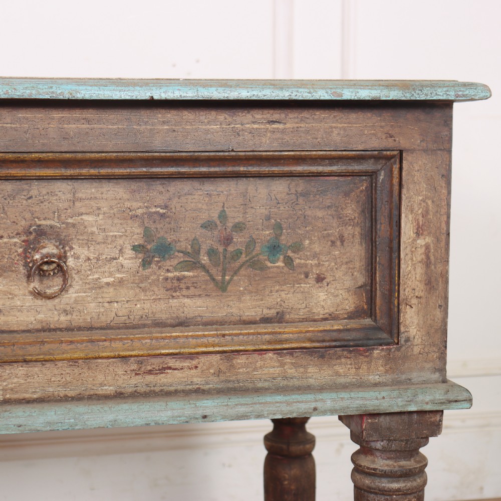 A long colonial painted wooden serving table featuring two drawers decorated with hand-painted floral motifs, brass ring handles, and four turned legs. View VI