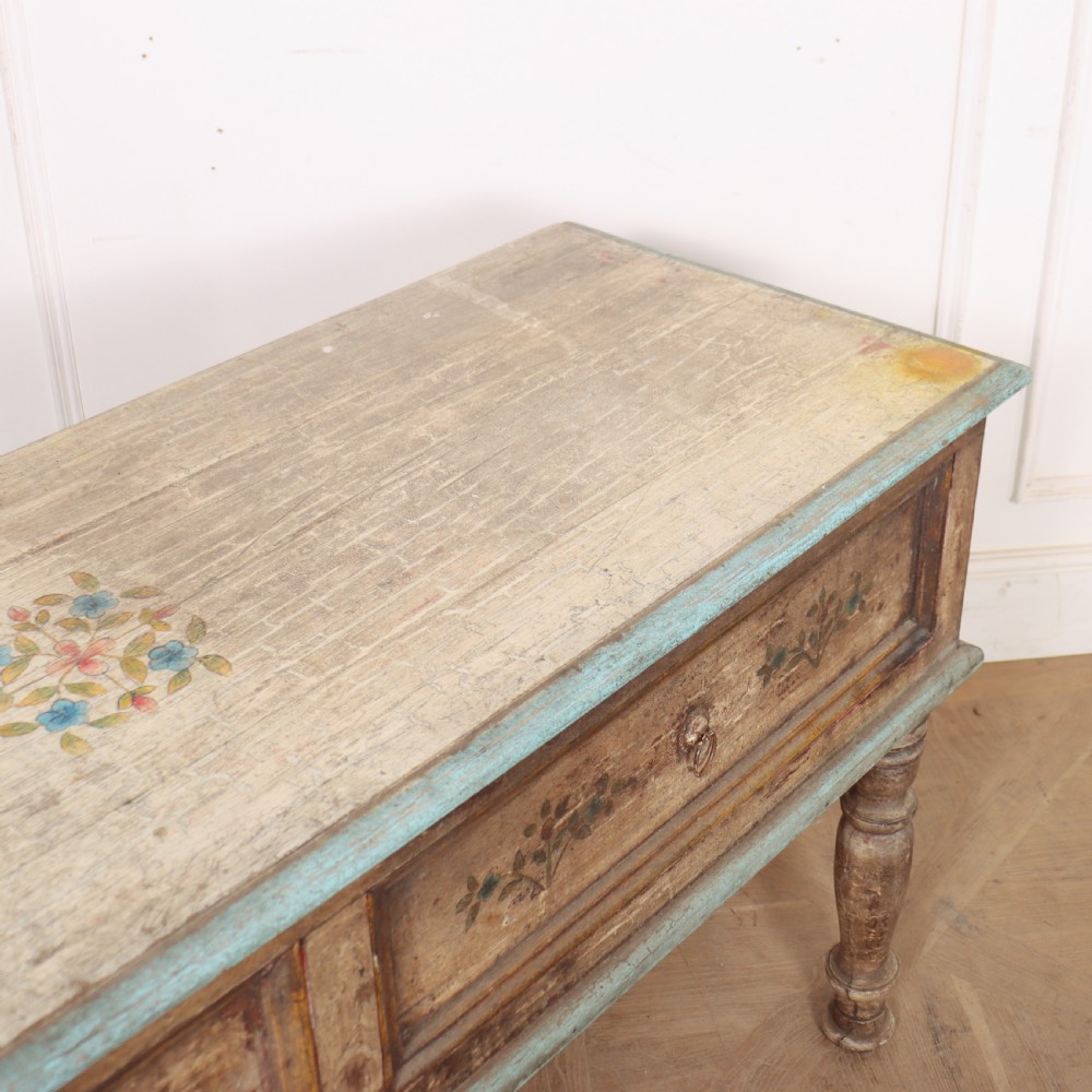A long colonial painted wooden serving table featuring two drawers decorated with hand-painted floral motifs, brass ring handles, and four turned legs. View IX