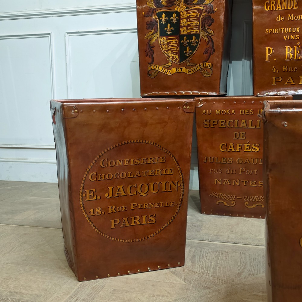 A collection of warm brown studded leather storage bins decorated with gilded French typography and heraldic crests. View III