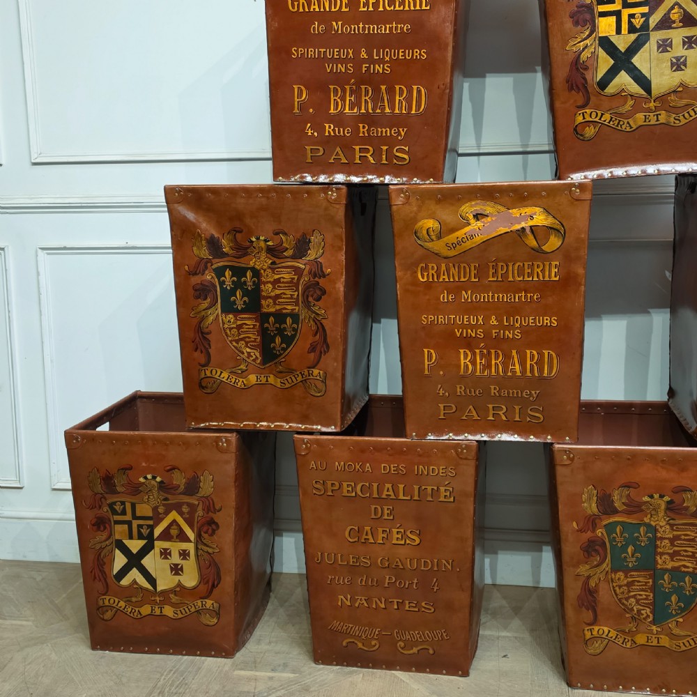 A collection of warm brown studded leather storage bins decorated with gilded French typography and heraldic crests. View IV
