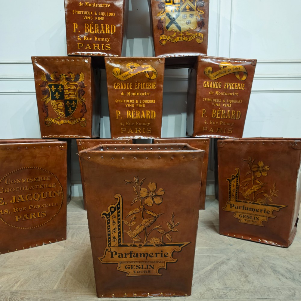 A collection of warm brown studded leather storage bins decorated with gilded French typography and heraldic crests. View V