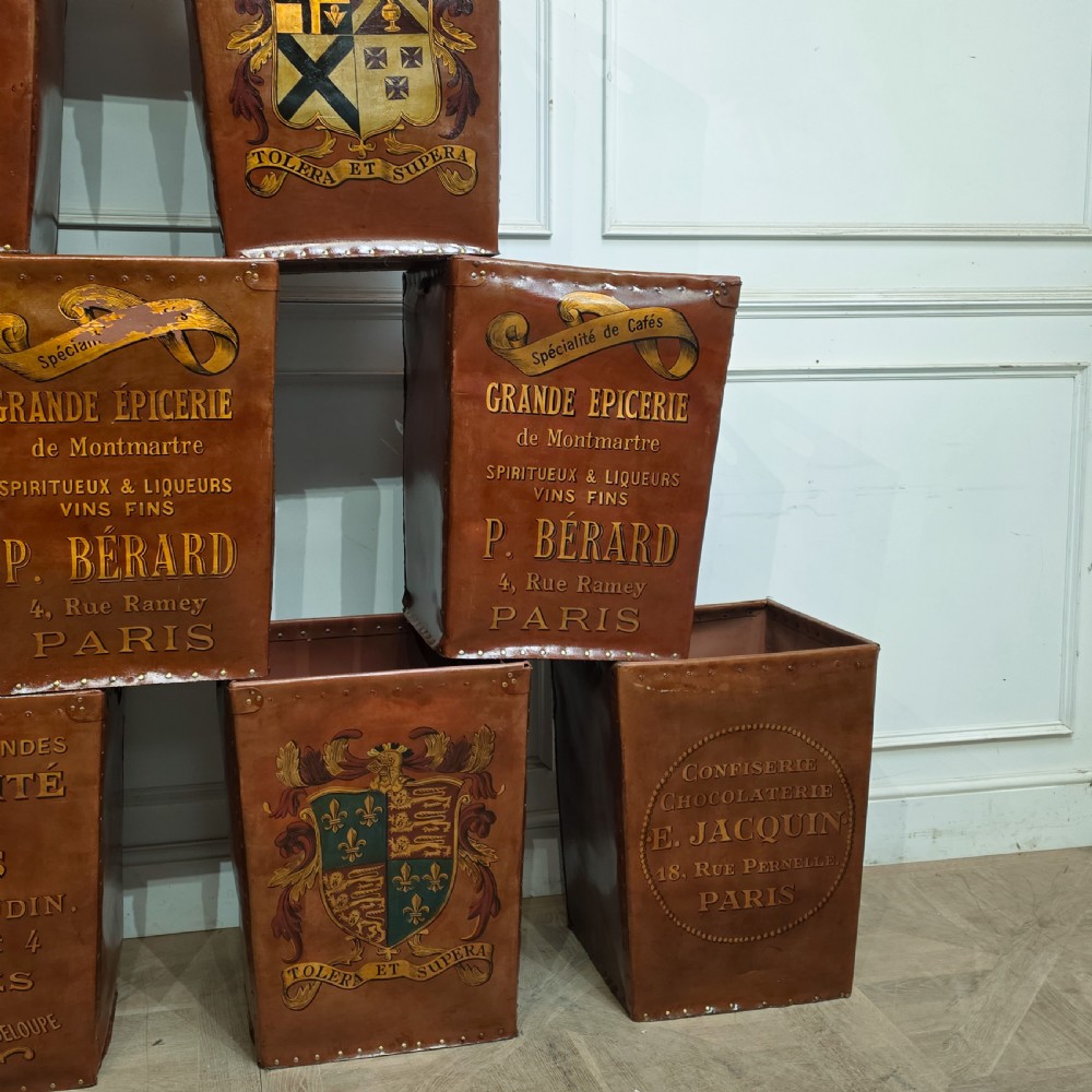 A collection of warm brown studded leather storage bins decorated with gilded French typography and heraldic crests. View VI