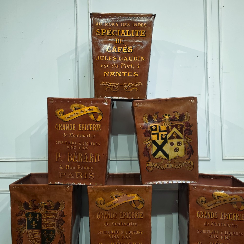 A collection of warm brown studded leather storage bins decorated with gilded French typography and heraldic crests. View VII