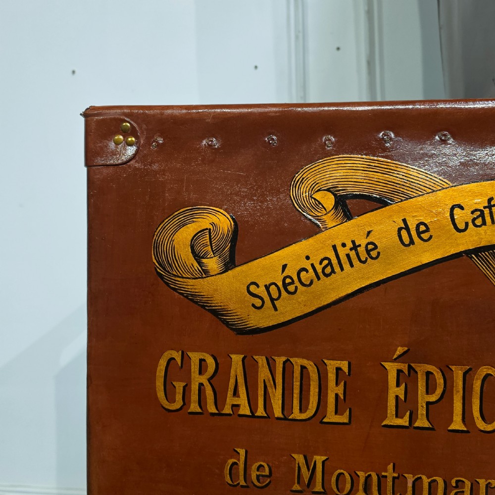 A collection of warm brown studded leather storage bins decorated with gilded French typography and heraldic crests. View VIII