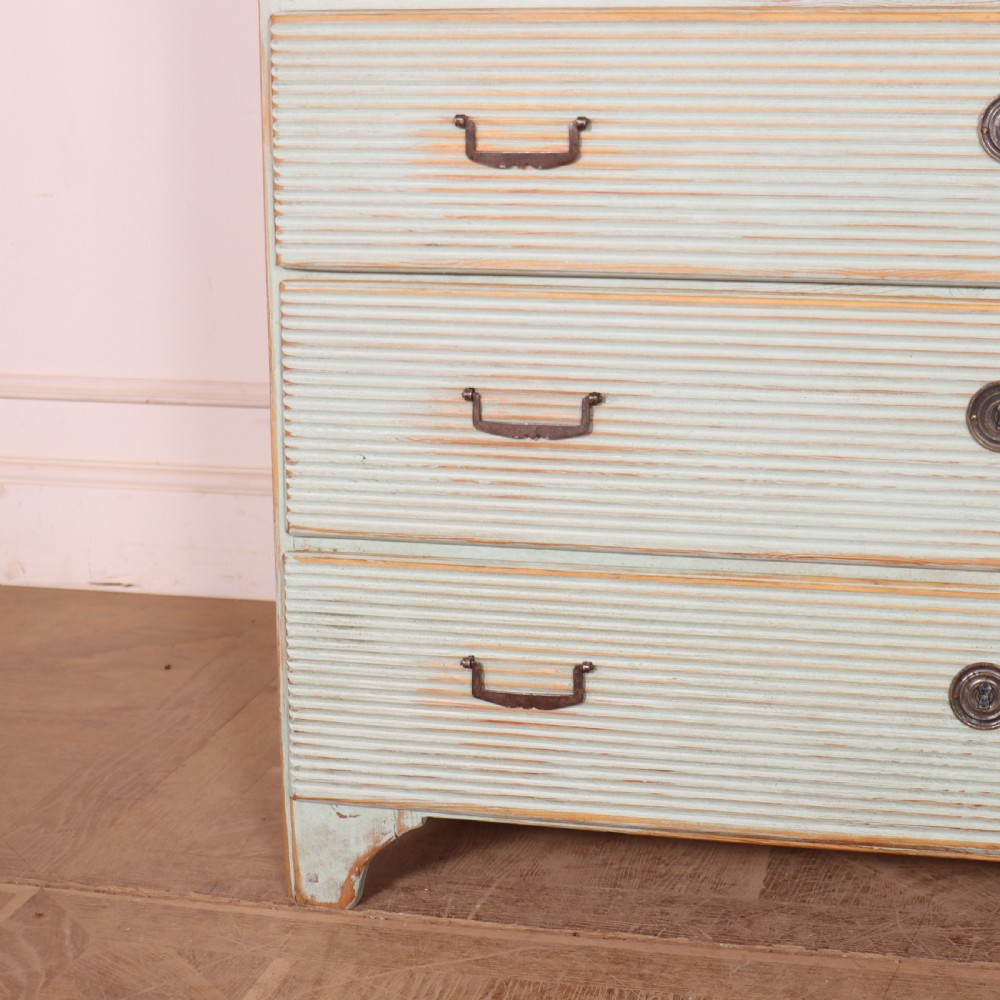 A Swedish painted pine commode featuring horizontal fluted drawer fronts, a pale blue distressed finish, and iron hardware. View V