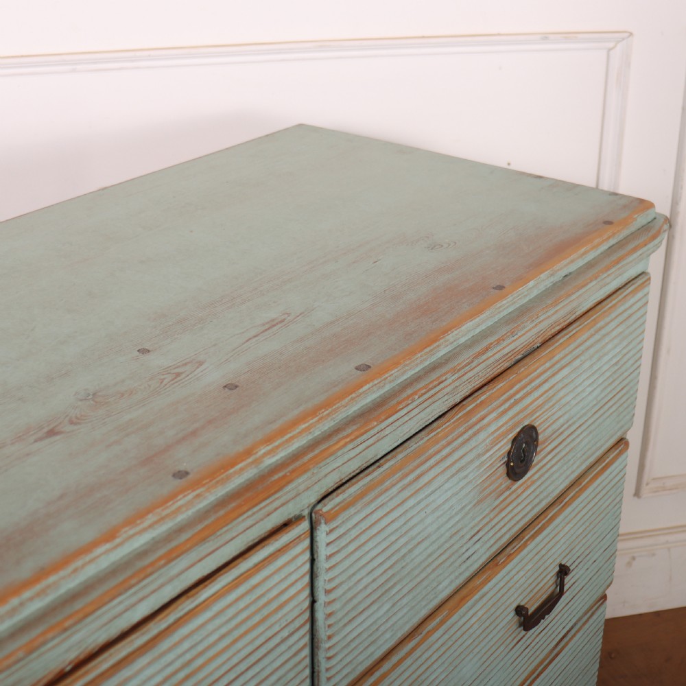 A Swedish painted pine commode featuring horizontal fluted drawer fronts, a pale blue distressed finish, and iron hardware. View X