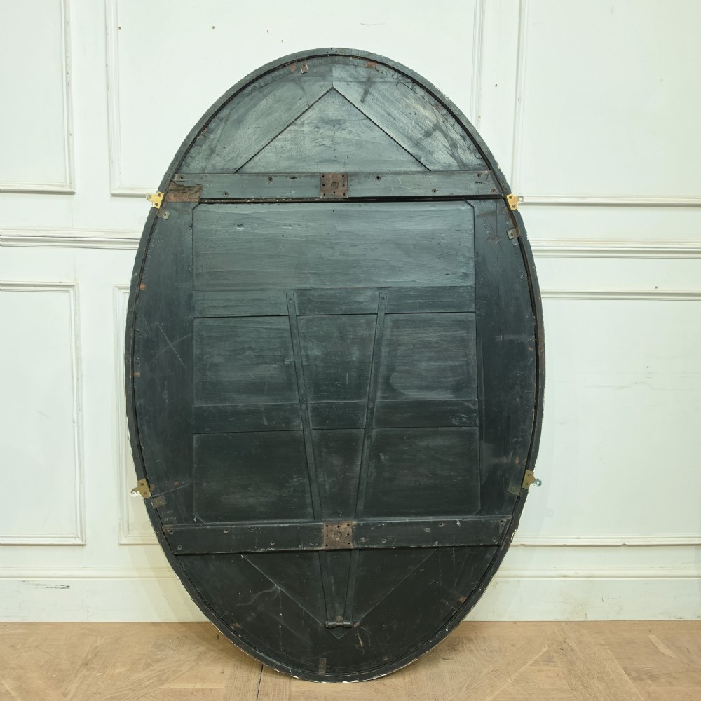 A large, vertical oval wall mirror featuring a gilt frame adorned with a studded beaded border. View VIII