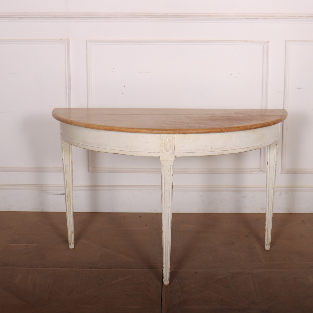 A Swedish demi-lune console table featuring a natural timber semicircular top, off-white painted apron with carved rosette detail, and fluted tapered legs.