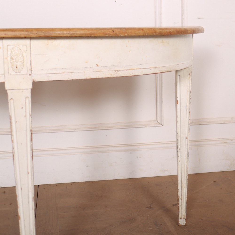 A Swedish demi-lune console table featuring a natural timber semicircular top, off-white painted apron with carved rosette detail, and fluted tapered legs. View IV