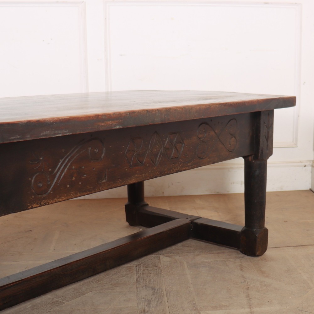 A large, low rectangular coffee table crafted from dark oak, featuring carved scroll patterns along the frieze and a sturdy stretcher base. View IV