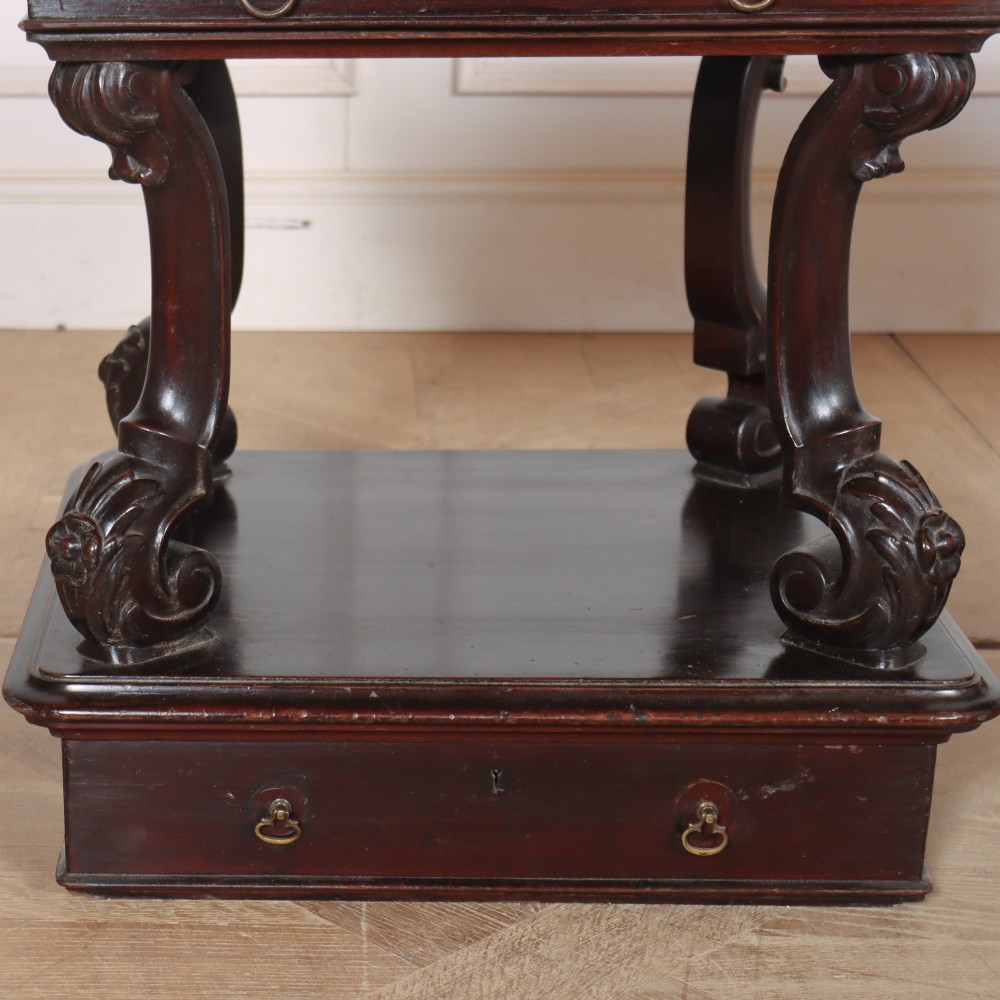 A pair of dark mahogany bedside tables featuring carved scroll supports, upper and lower drawers with brass drop-ring handles, resting on solid plinth bases. View III