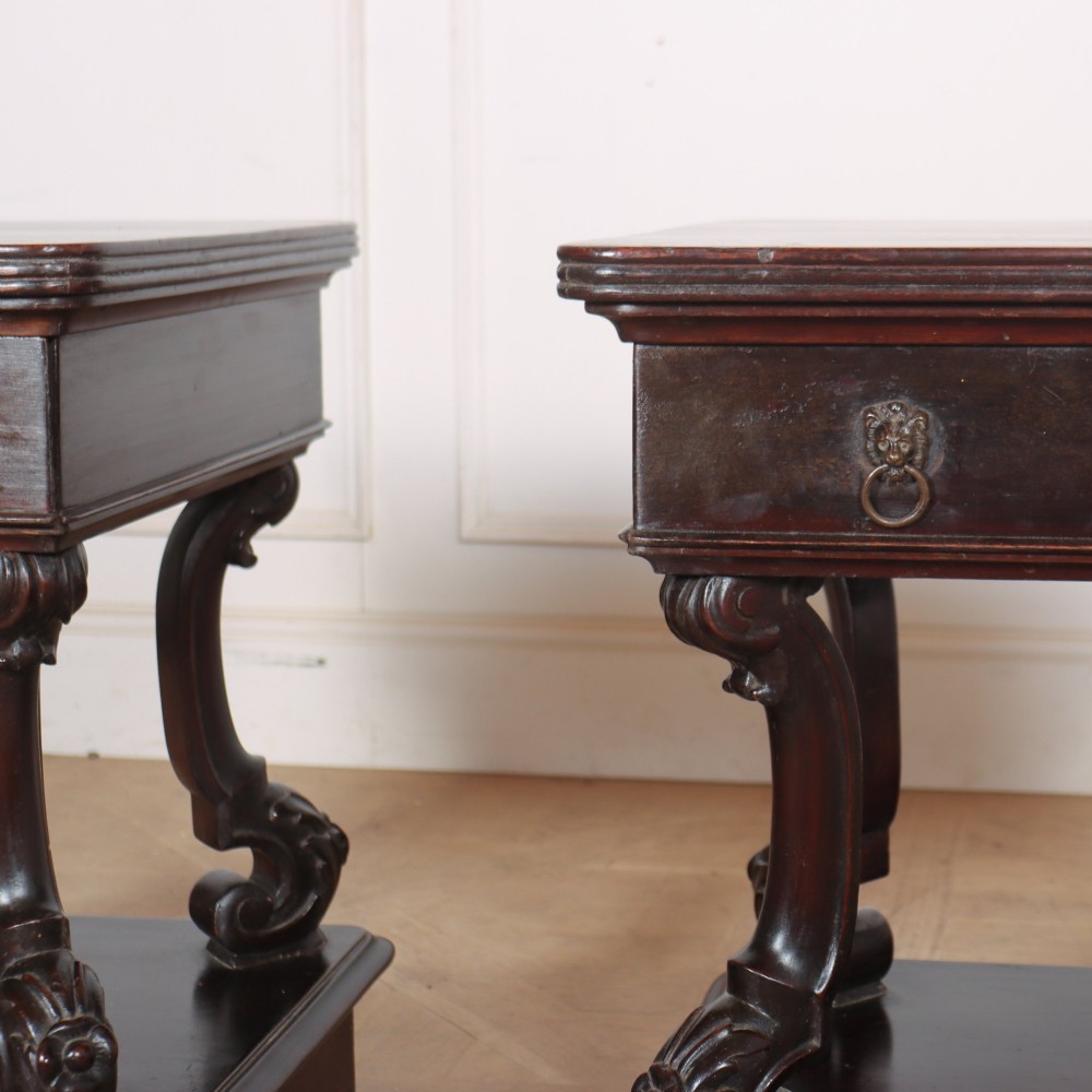 A pair of dark mahogany bedside tables featuring carved scroll supports, upper and lower drawers with brass drop-ring handles, resting on solid plinth bases. View VIII