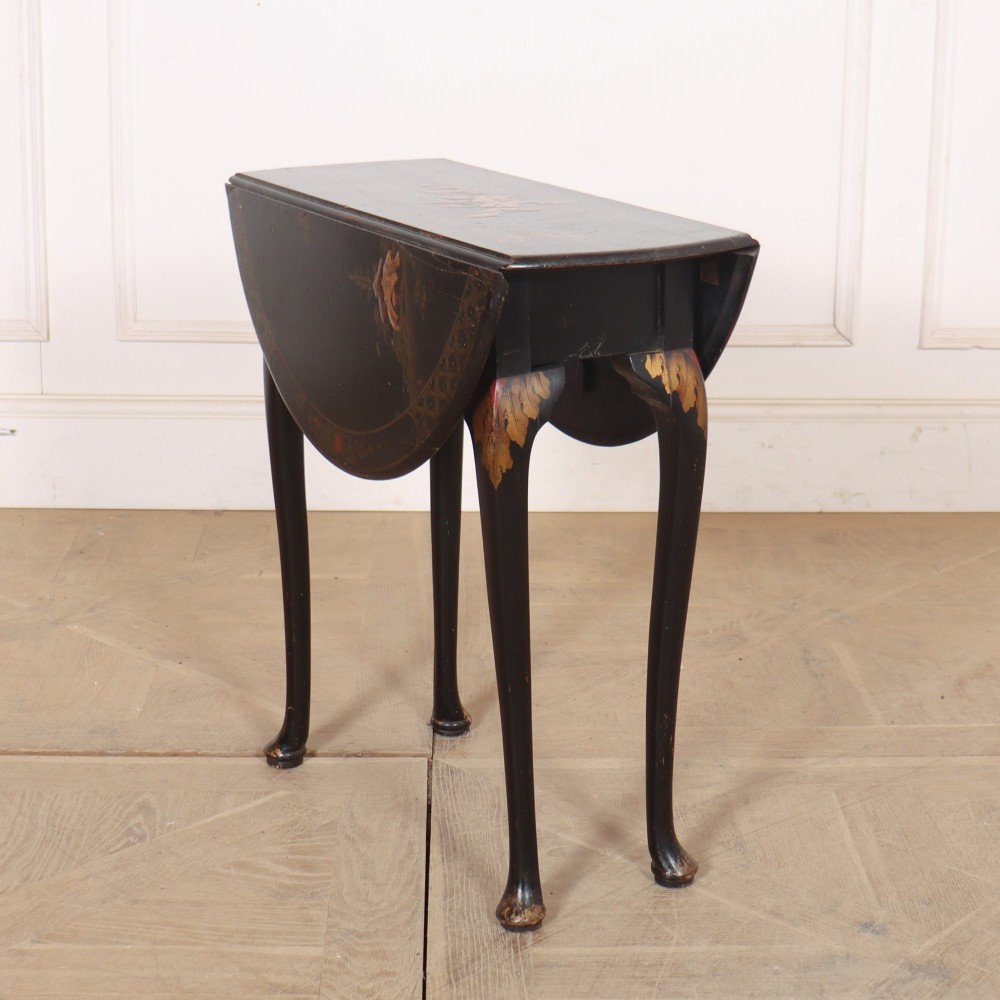 A small black lacquered drop-leaf side table decorated with gold Chinoiserie painted details and slender cabriole legs.