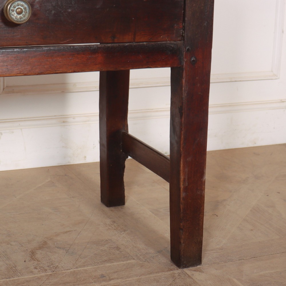 A dark-stained Welsh oak dresser base featuring two wide drawers with circular knobs and a light scrubbed timber top surface. View V