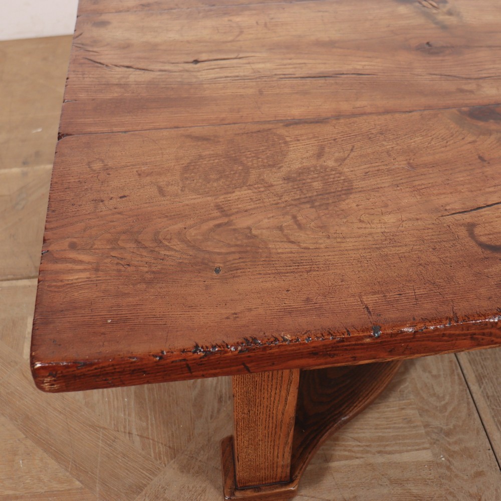 A rectangular warm brown solid elm coffee table with a thick plank top and a distinctive X-shaped lower stretcher base. View IV
