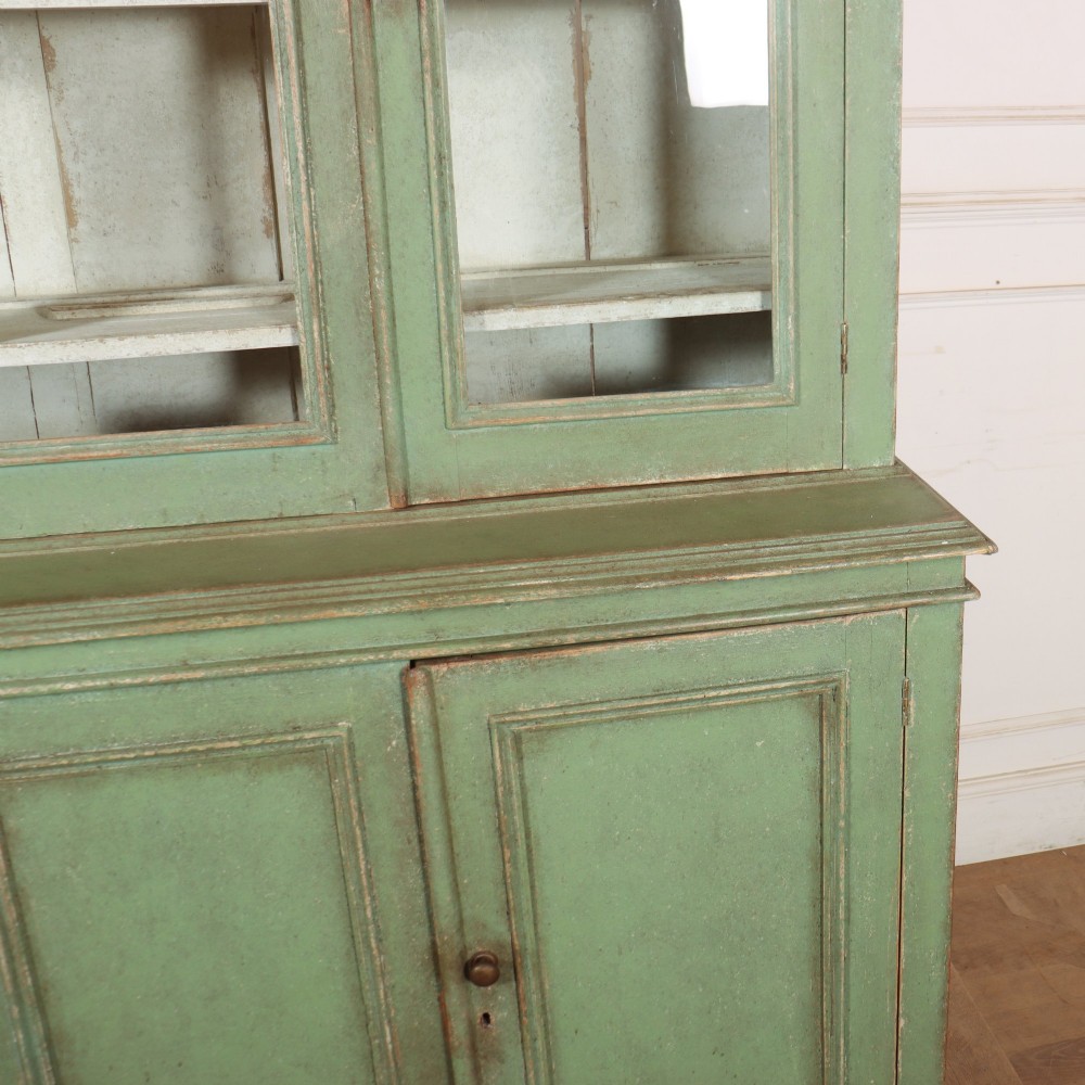 A large sage green painted wooden kitchen dresser with three upper glazed cabinet doors and three lower solid panelled doors. View VI