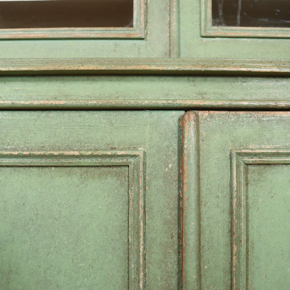 A large sage green painted wooden kitchen dresser with three upper glazed cabinet doors and three lower solid panelled doors. View IX
