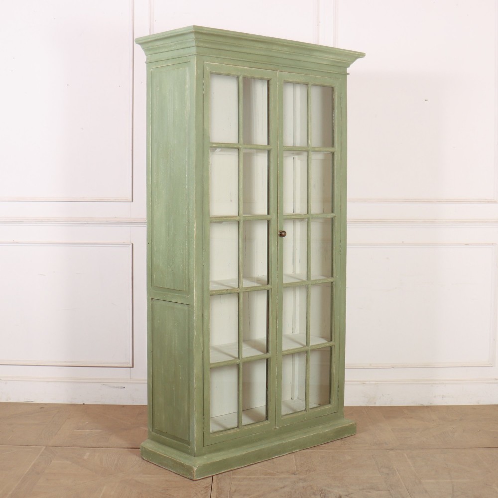 A tall 19th-century English glazed bookcase painted in sage green featuring twin multi-pane glass doors and a white painted interior. View IX