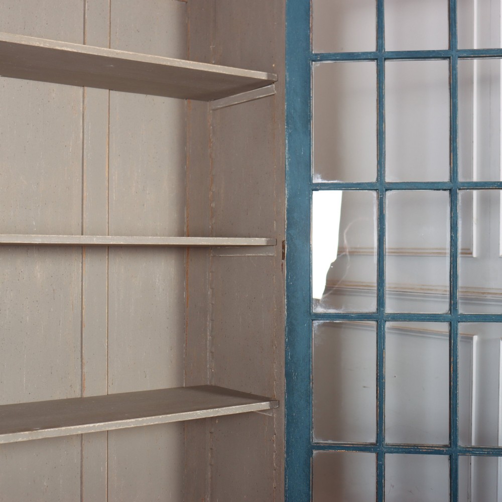 A pair of tall painted teal blue wooden library bookcases with multi-pane glazed doors, moulded cornices, and lower paneled drawers. View XI