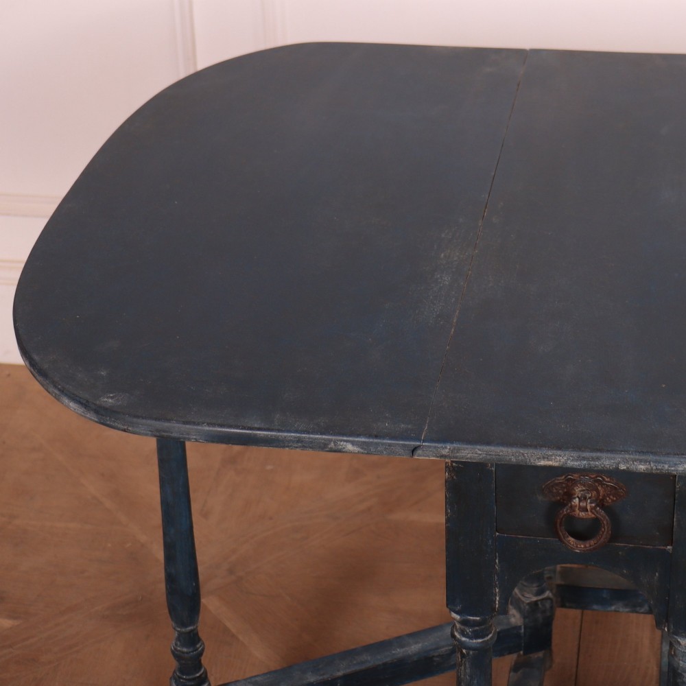 A blue painted antique spider leg drop-leaf table shown with its hinged side leaves folded down, revealing slender turned legs and stretchers. View V