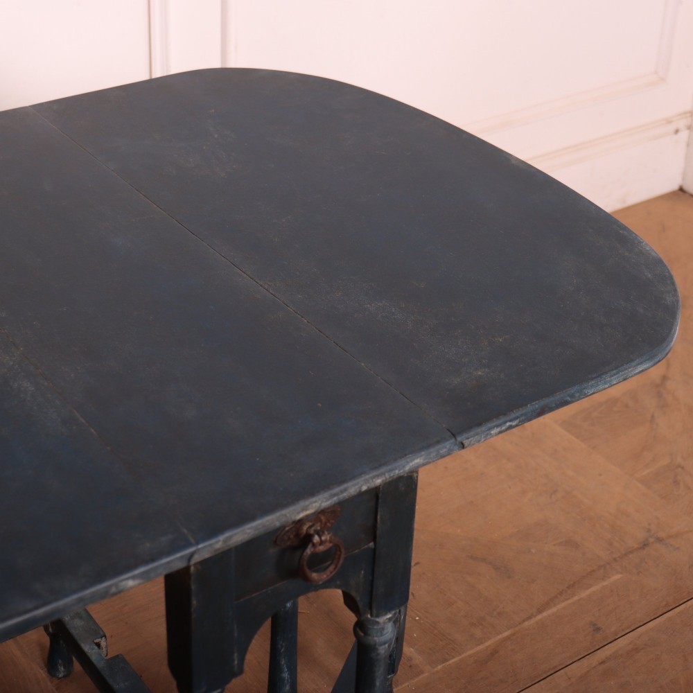 A blue painted antique spider leg drop-leaf table shown with its hinged side leaves folded down, revealing slender turned legs and stretchers. View VI