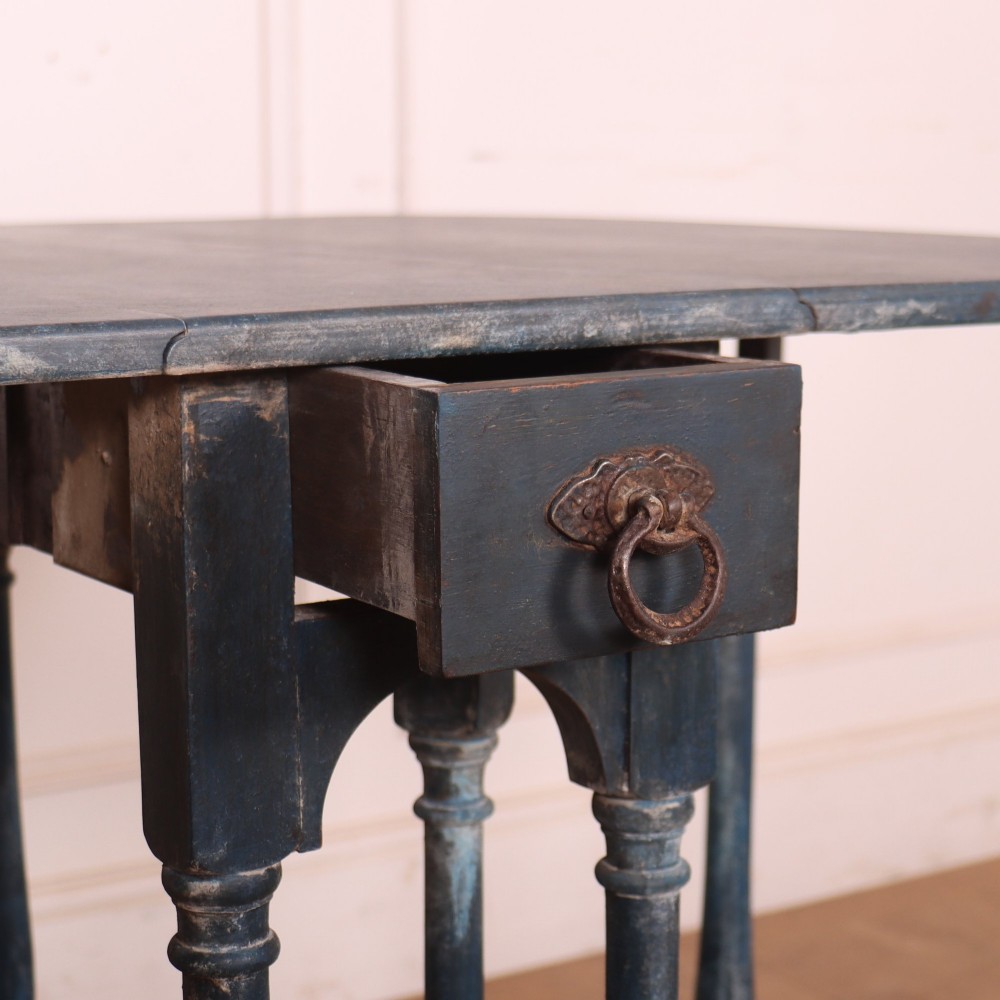A blue painted antique spider leg drop-leaf table shown with its hinged side leaves folded down, revealing slender turned legs and stretchers. View VII