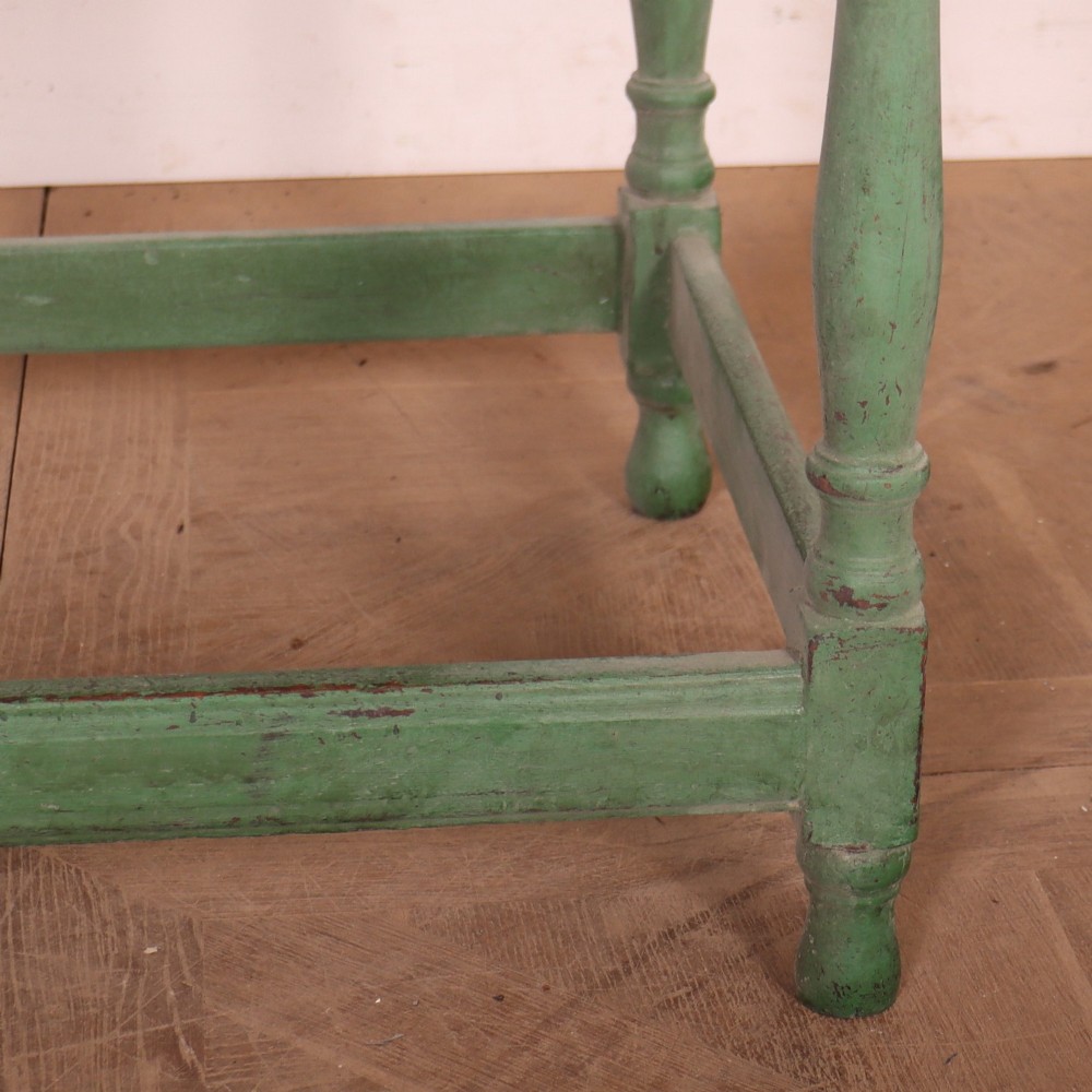 An antique English oak lamp table featuring a distressed green painted finish, two drawers with brass handles, turned legs, and a lower stretcher base. View IV