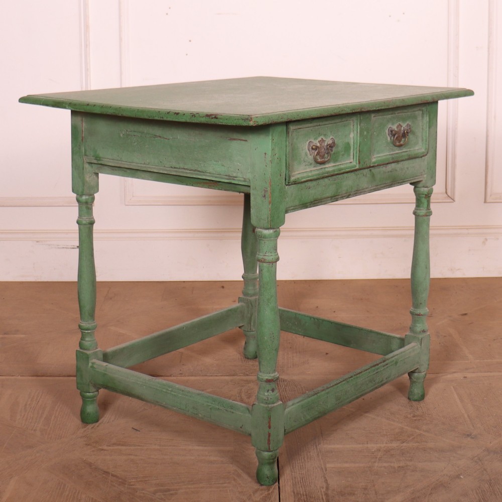 An antique English oak lamp table featuring a distressed green painted finish, two drawers with brass handles, turned legs, and a lower stretcher base. View VI