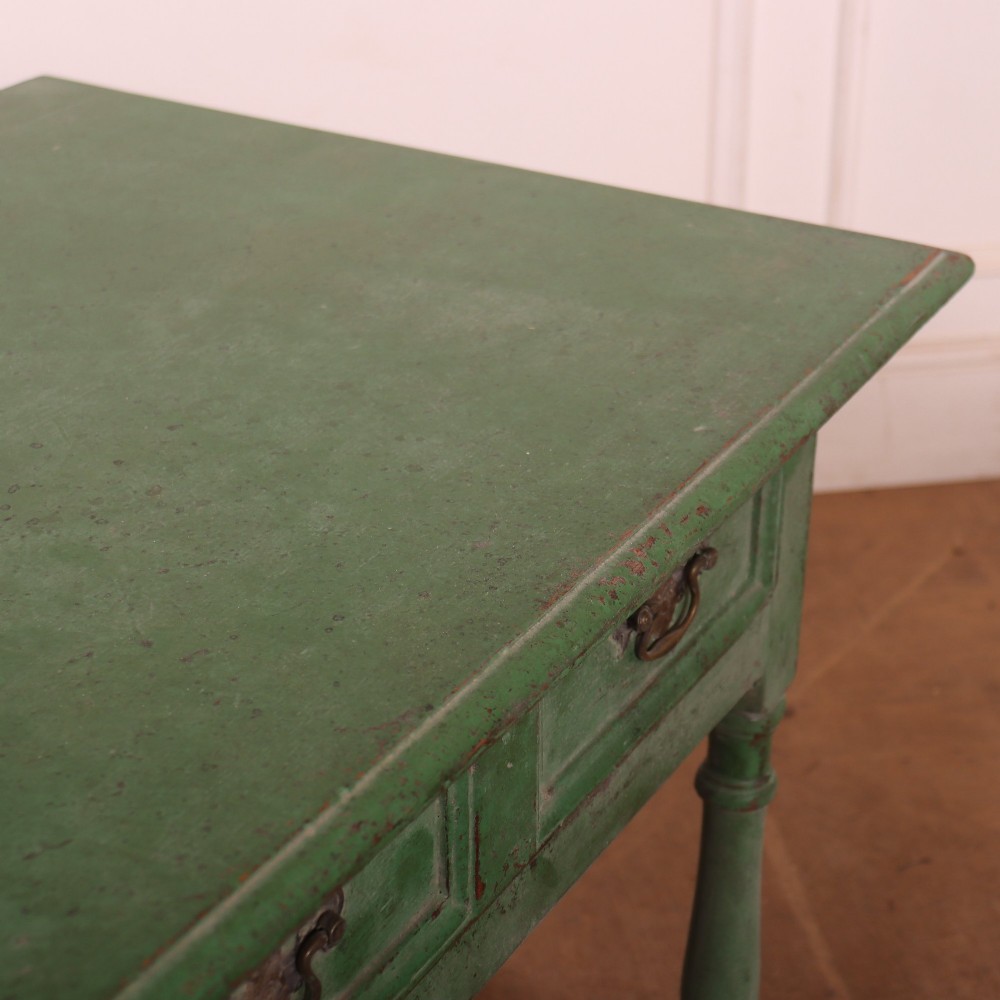 An antique English oak lamp table featuring a distressed green painted finish, two drawers with brass handles, turned legs, and a lower stretcher base. View VIII