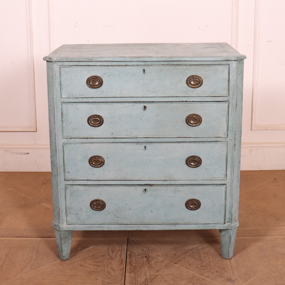 A pale blue painted Swedish commode with four drawers, oval brass pull handles, and square tapered feet.
