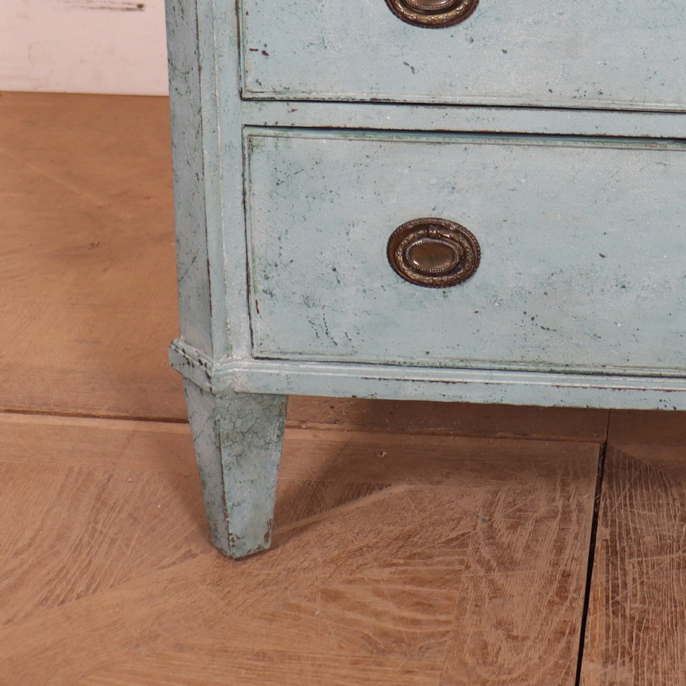 A pale blue painted Swedish commode with four drawers, oval brass pull handles, and square tapered feet. View V