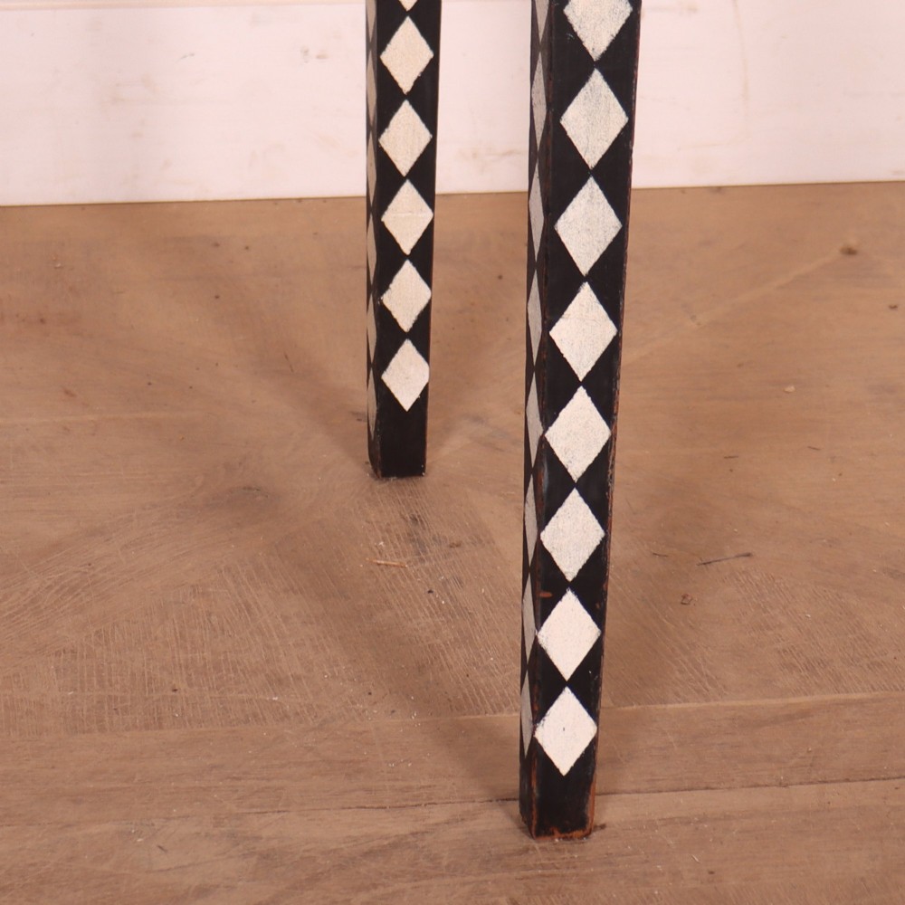 A rectangular black painted lamp table featuring a hand-painted cream and black harlequin diamond pattern on the front drawer and square legs, finished with two brass ring pull handles. View IV