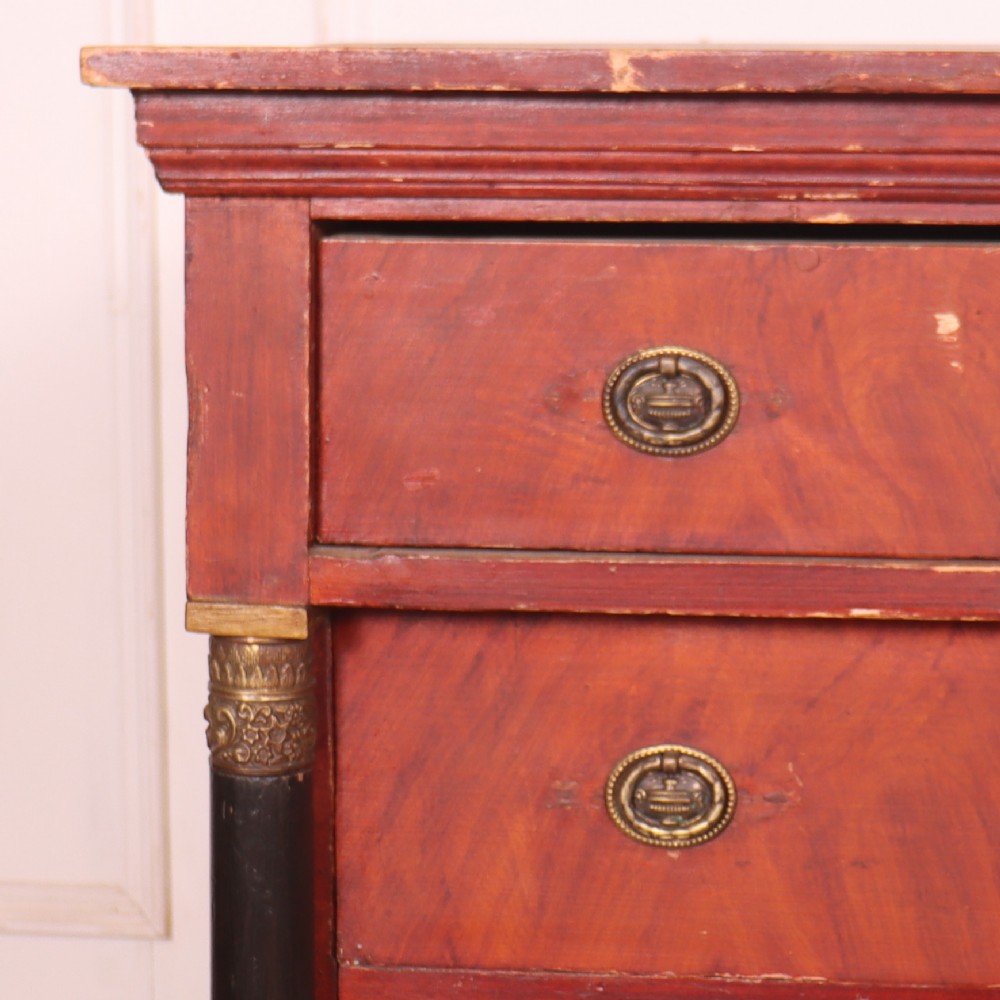 A Dutch Empire style red mahogany commode with four drawers, ebonised side columns, and round brass handles. View II