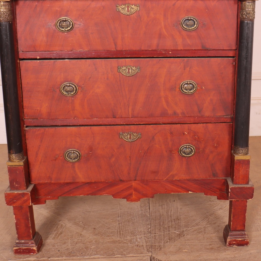 A Dutch Empire style red mahogany commode with four drawers, ebonised side columns, and round brass handles. View IV