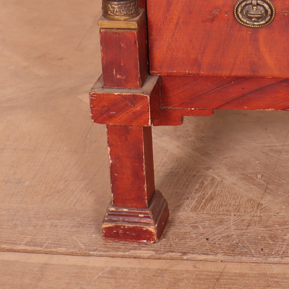 A Dutch Empire style red mahogany commode with four drawers, ebonised side columns, and round brass handles. View V